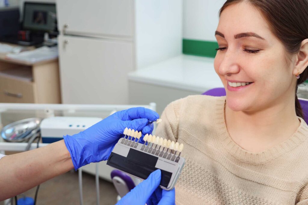 02 Una dentista exhibe las muestras de color de dientes de ceramica para que una paciente joven elija