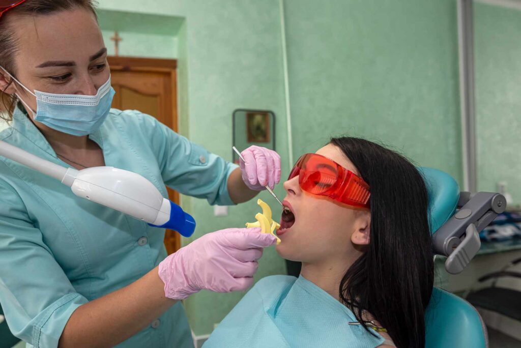 05 Una dontologa preparando a una paciente para un tipo de blanqueamiento dental mediante fotoactivacion